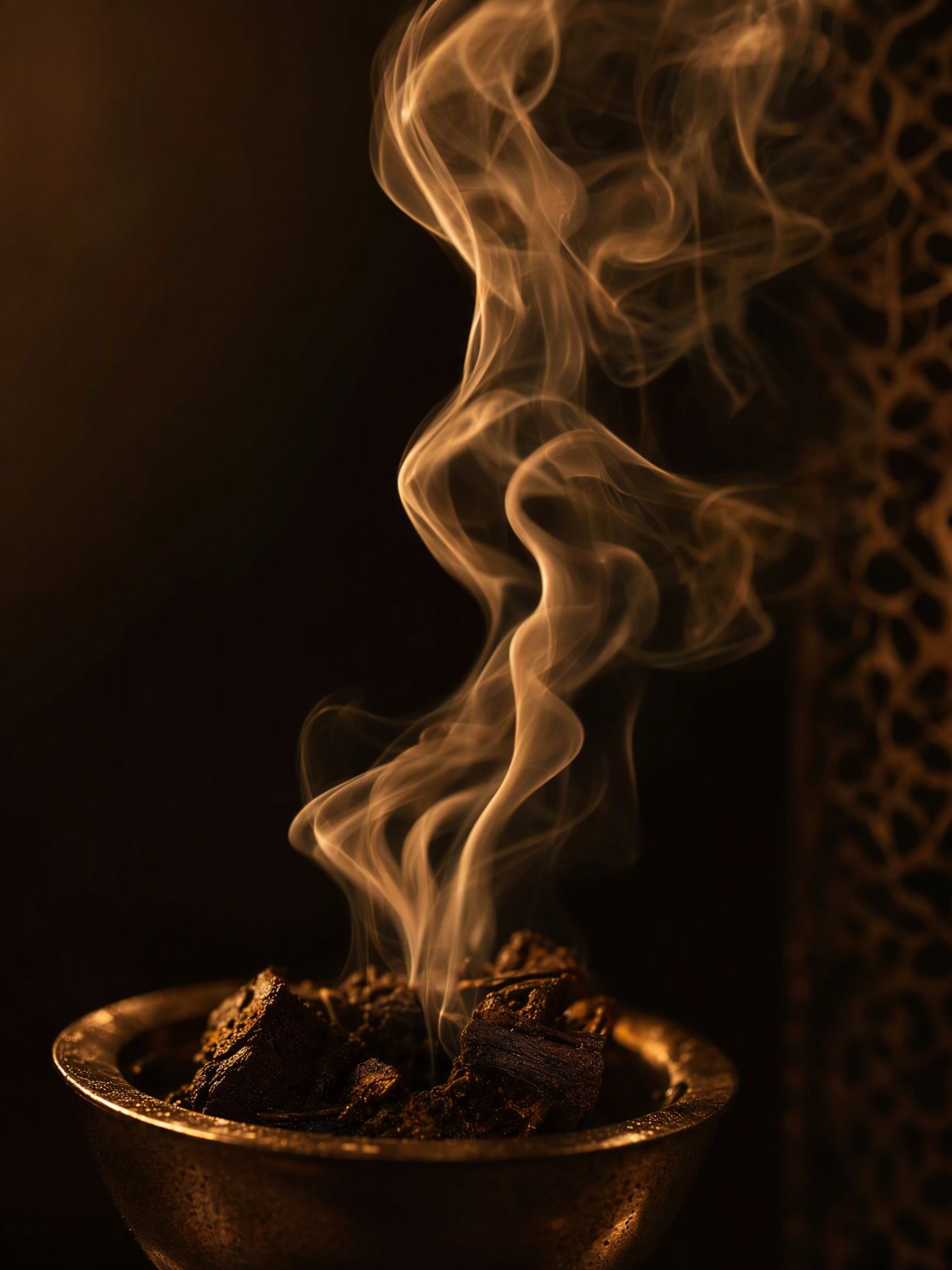 Bakhoor — scented incense chips heaped in a carved wooden bowl